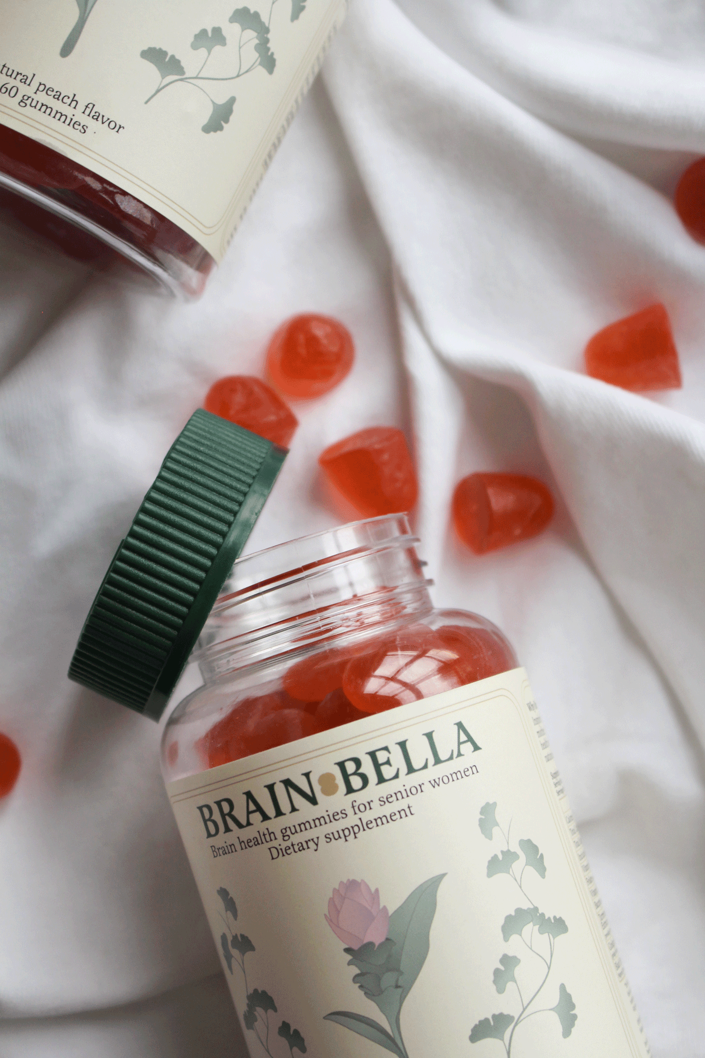 Bottle of Brain Bella dietary supplement with gummies on a white fabric background